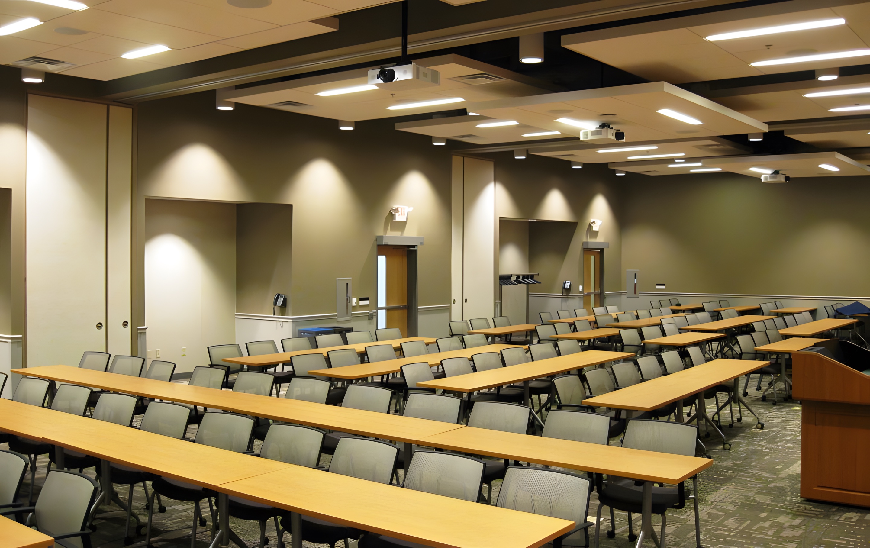 A large training room with rows of tables under even ceiling lighting