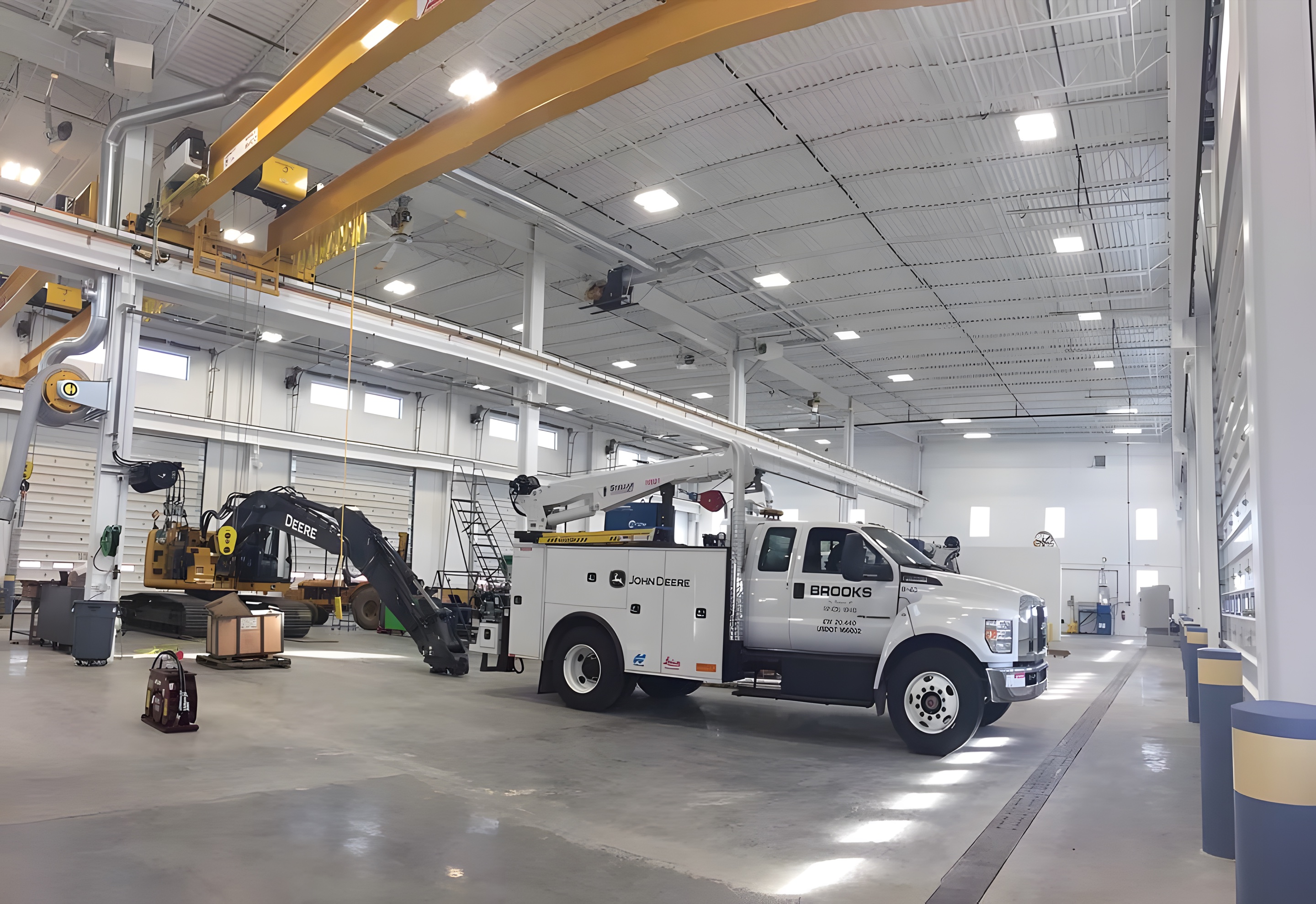 A bright service bay with high-bay lighting and a work truck