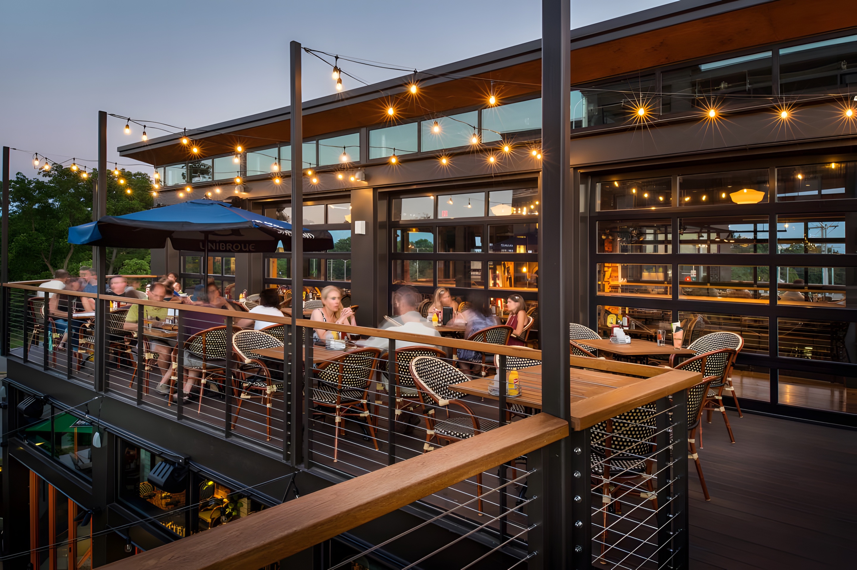 A rooftop terrace at dusk under string lights
