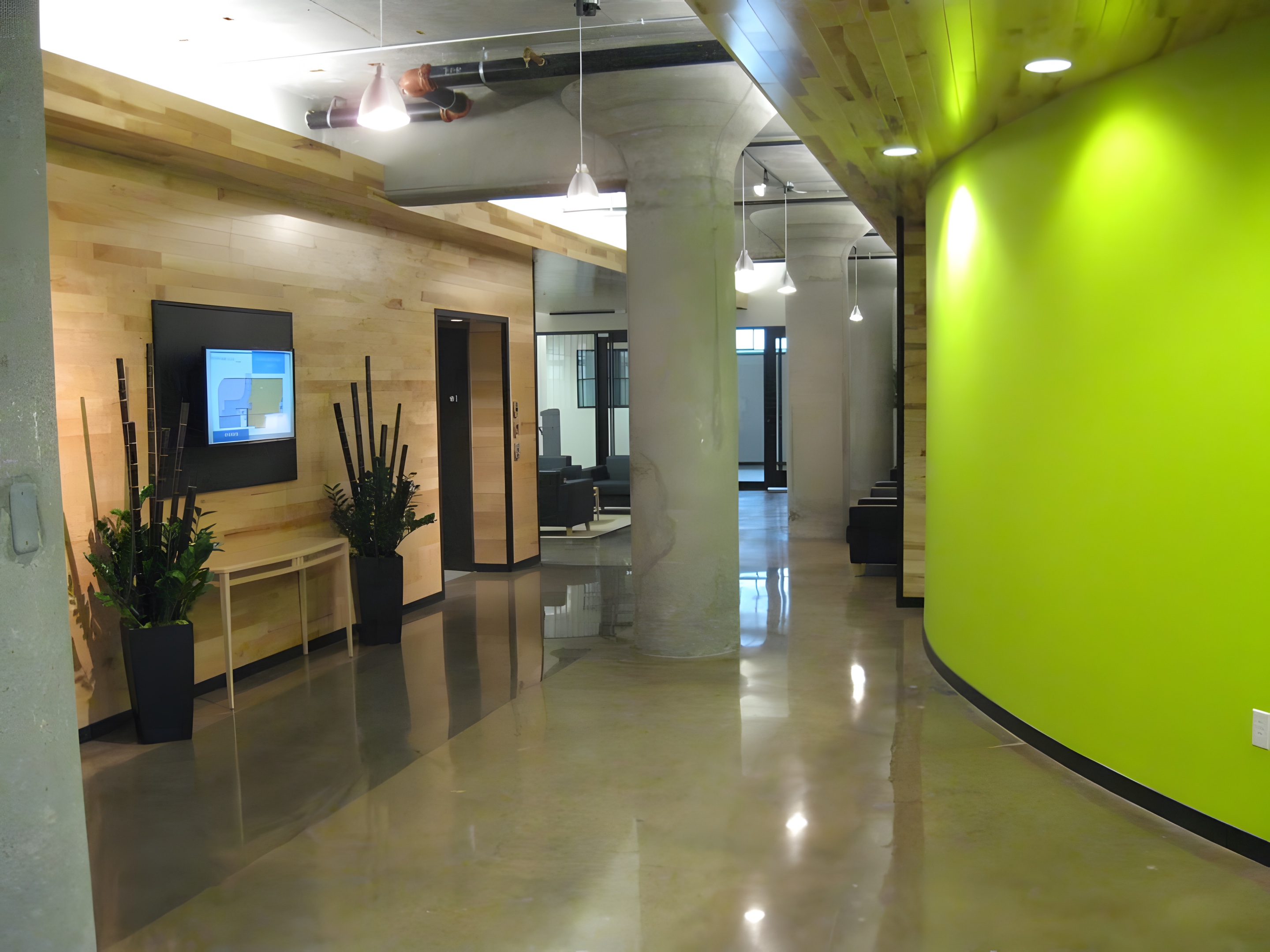 A loft hallway with concrete columns and wall-washed lighting